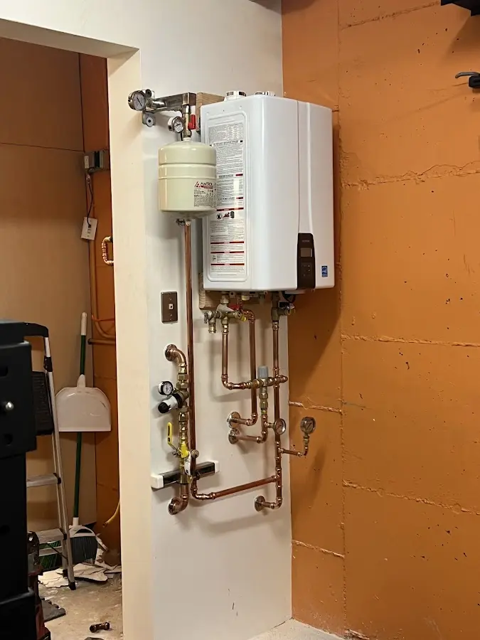 Plumbing technician inspecting water heater connections in Bridge City